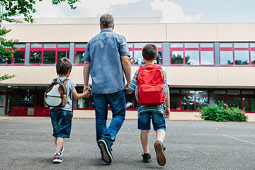 Dad walking kids to school